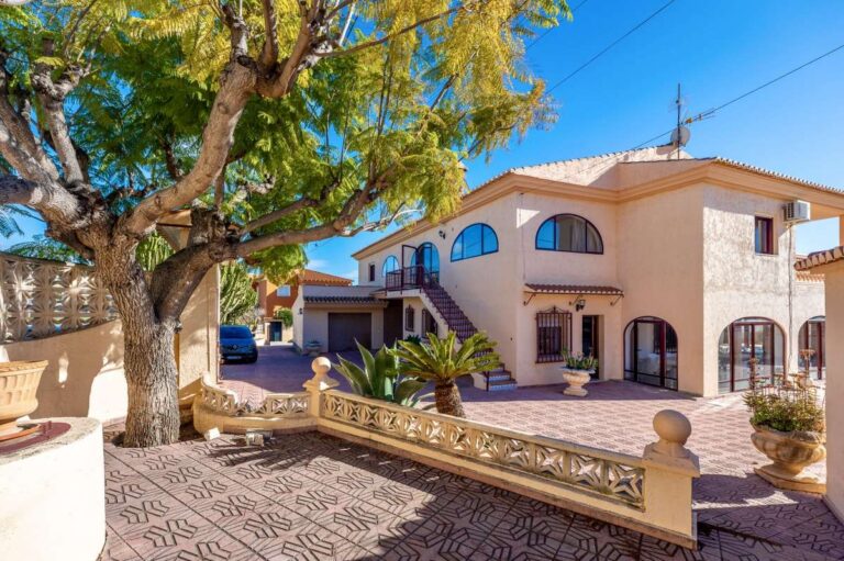 Exterior view of a spacious villa with guest apartments, arched windows and garden area in Calpe.S