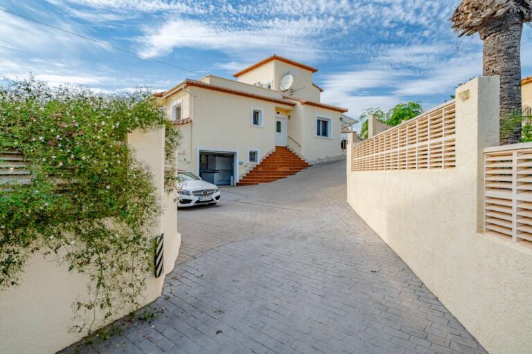 Exterior view of a villa in Calpe with private driveway, garage access and walled entrance