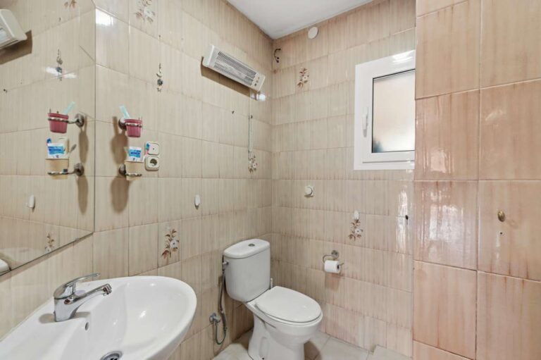 Family bathroom inside a Mediterranean villa in Benissa Costa with bath, toilet, tiled walls and window for natural light