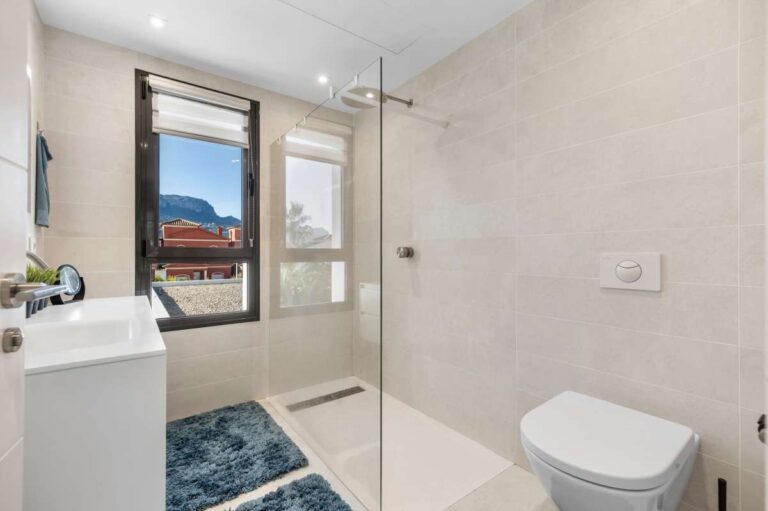 Family bathroom with vanity, toilet and natural light inside a modern oasis villa near Arenal-Bol Beach in Calpe.