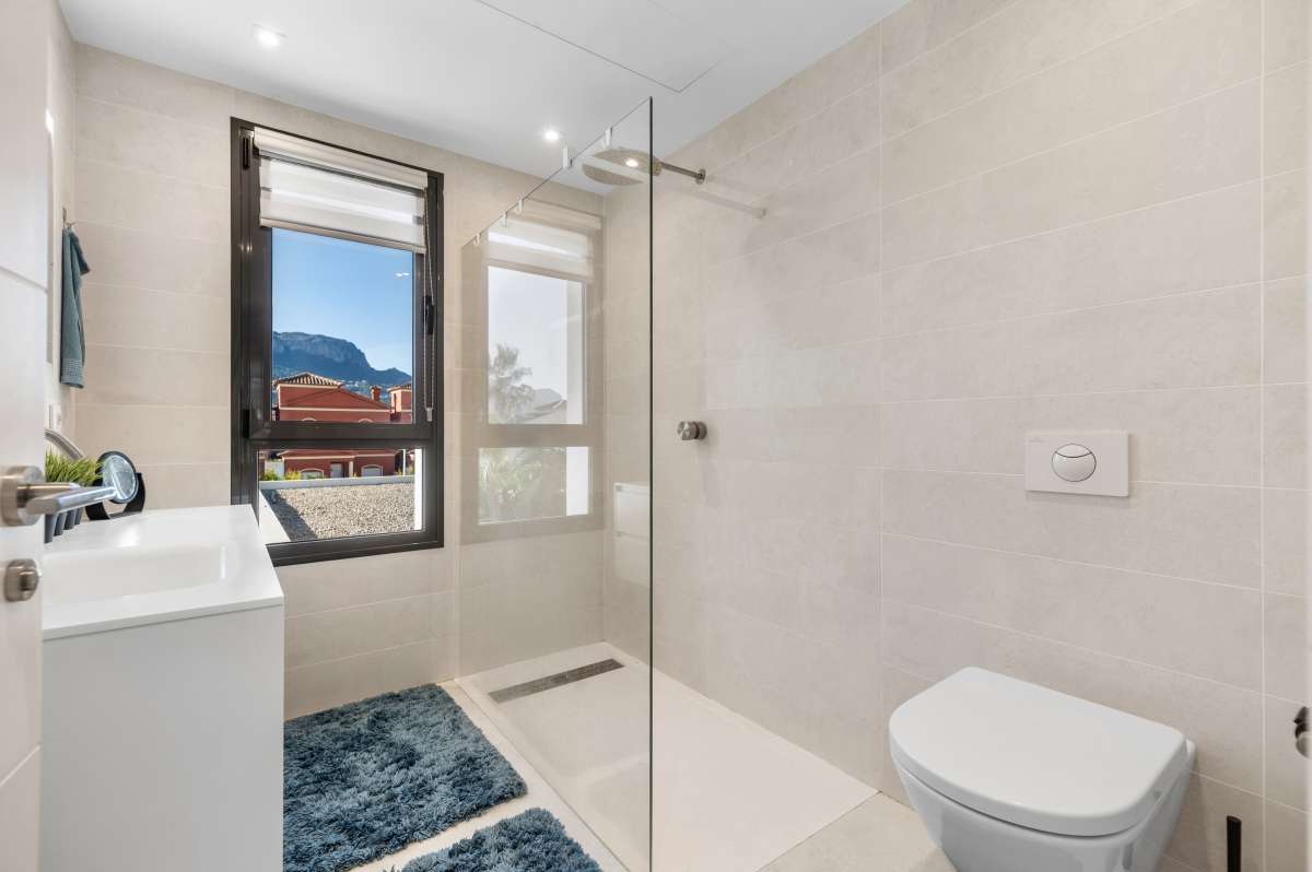 Family bathroom with vanity, toilet and natural light inside a modern oasis villa near Arenal-Bol Beach in Calpe.
