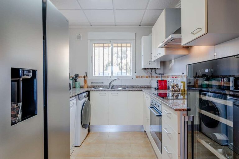Fitted kitchen inside a semi-detached house in Calpe with appliances, tiled floor and natural light