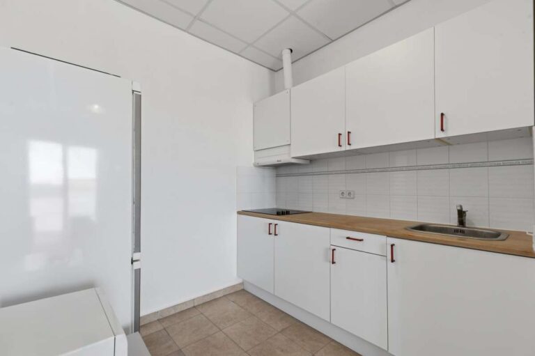 Fitted kitchen with white cabinets and worktop inside a villa in Calpe.