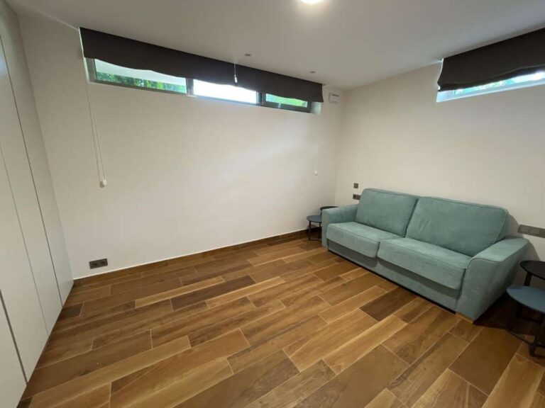Flexible guest room inside a modern luxury villa in La Calalga, Calpe with sofa bed, wooden flooring, fitted storage and bright interior finish