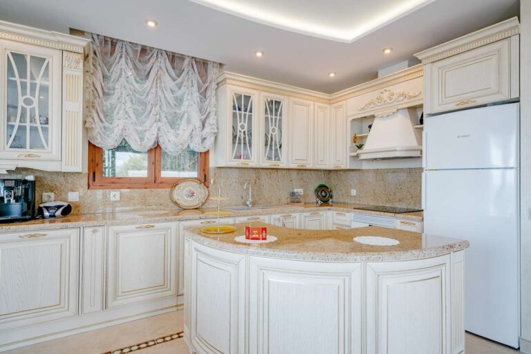 Fully equipped kitchen with traditional cabinetry and quality finishes inside a frontline villa on the Benissa Coast.