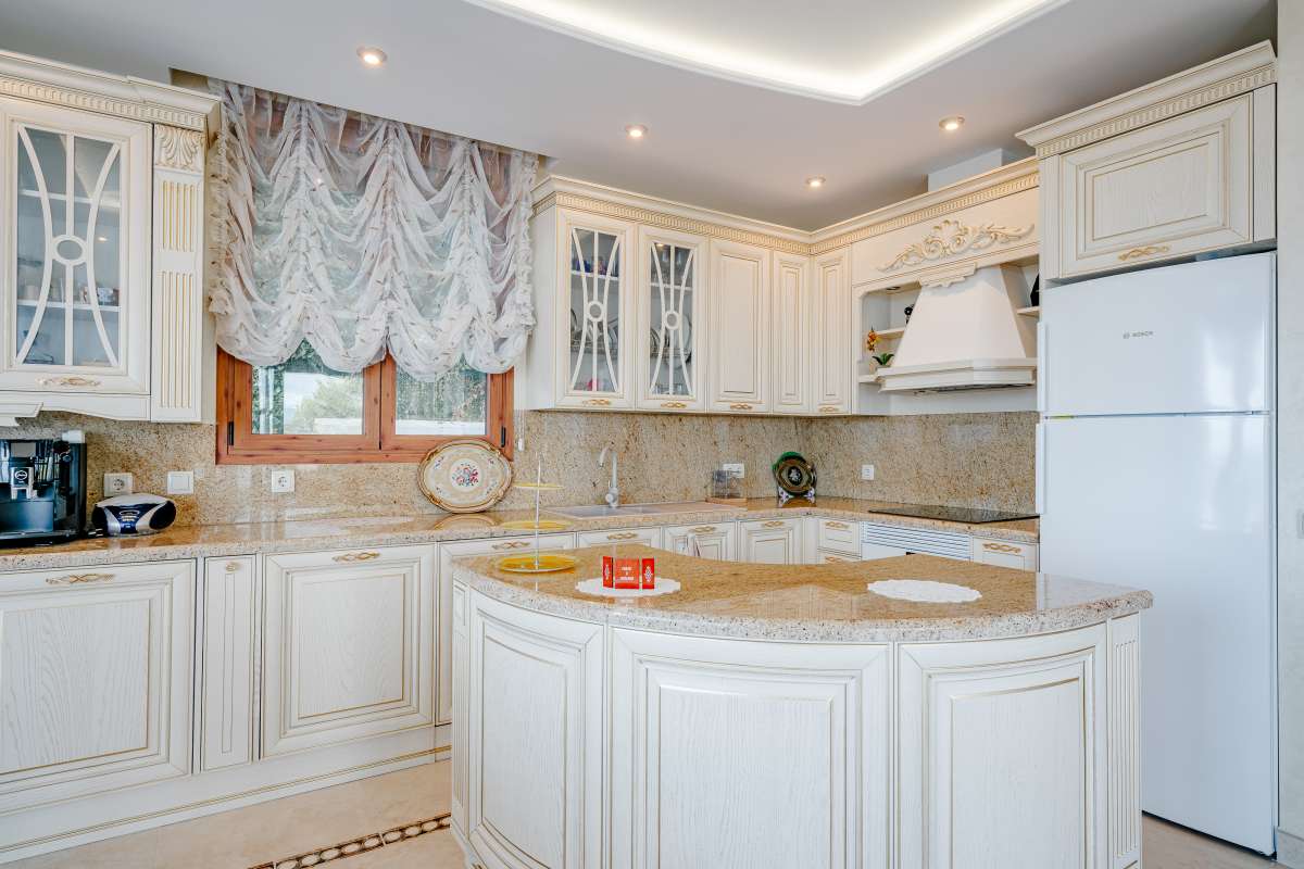 Fully equipped kitchen with traditional cabinetry and quality finishes inside a frontline villa on the Benissa Coast.
