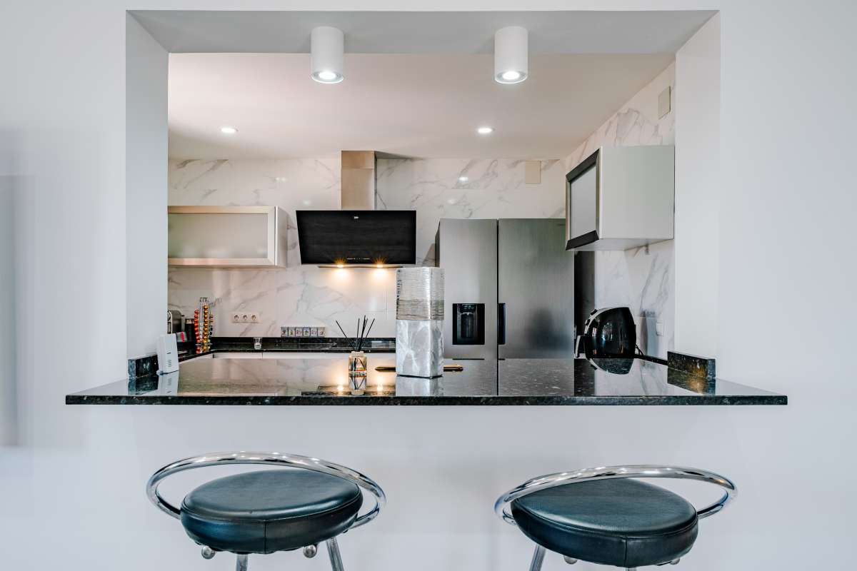 Fully equipped open-plan kitchen with breakfast bar inside a renovated Mediterranean villa in La Cometa, Calpe.