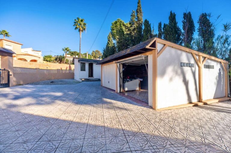 Garage and parking area at a south-facing single-level villa in Calpe with space for several cars.