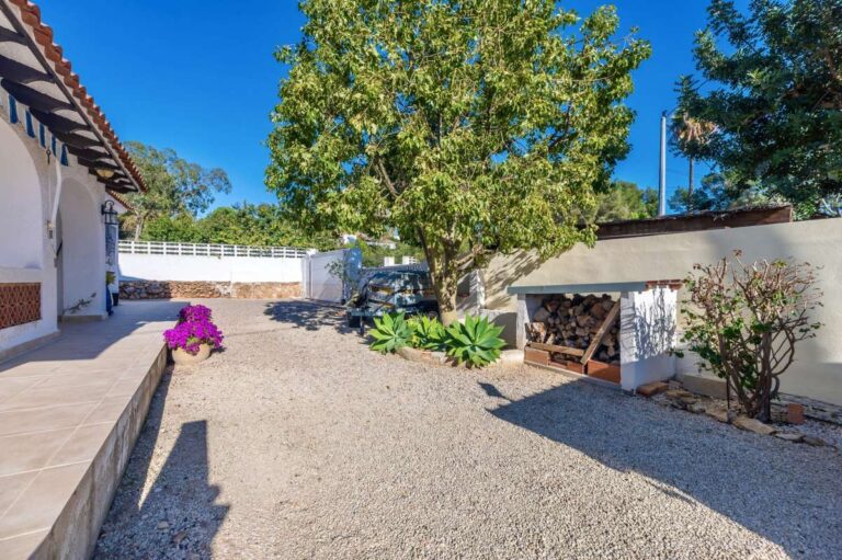 Garden and driveway area with mature trees beside a contemporary villa in a peaceful residential area of Calpe.