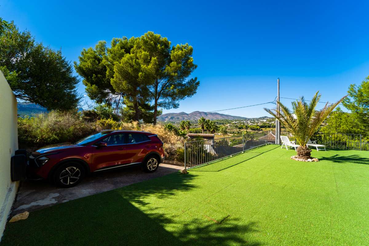 Garden and parking area with mountain surroundings at a Mediterranean villa in Cometa III, Calpe.