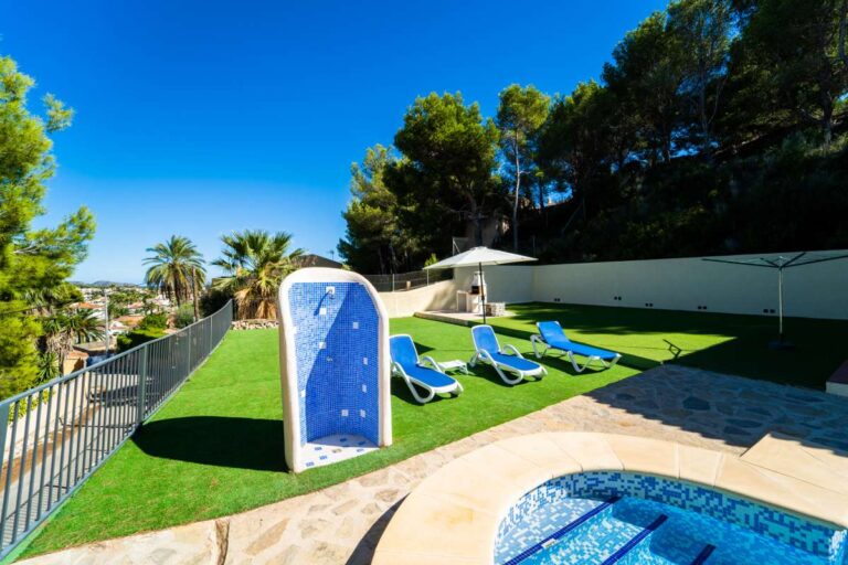 Garden and pool area with sun loungers and mountain surroundings at a Mediterranean villa in Cometa III, Calpe.