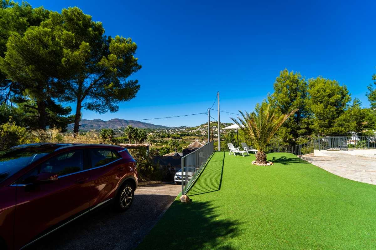 Garden area with mountain views, trees and parking space at a Mediterranean villa in Calpe.