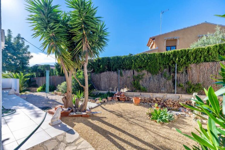 Garden area with palm trees and Mediterranean planting beside a contemporary villa in Calpe.
