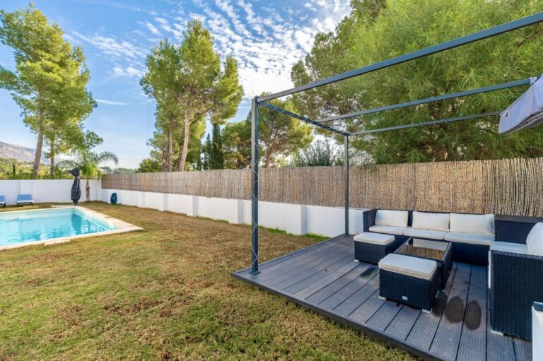 Garden lounge area at a single-level modern villa in Santa Clara, Altea with outdoor seating, saltwater pool, lawn and private garden surroundings