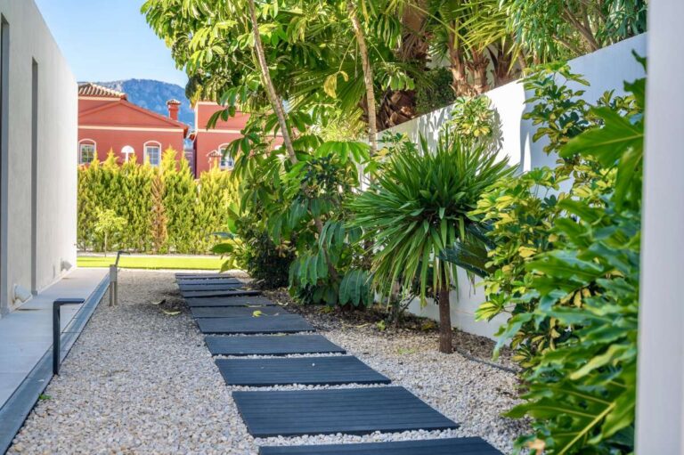 Garden pathway with tropical planting and gravel landscaping at a modern oasis villa in Calpe.