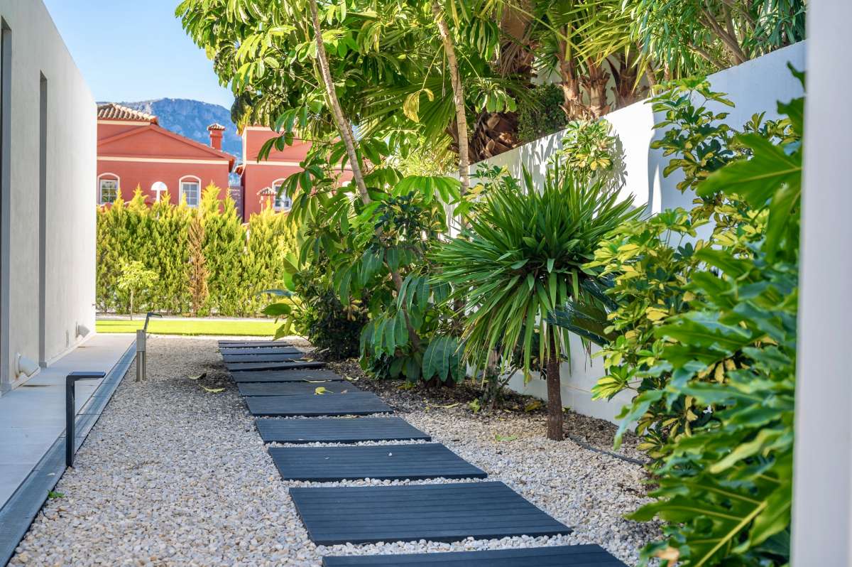 Garden pathway with tropical planting and gravel landscaping at a modern oasis villa in Calpe.