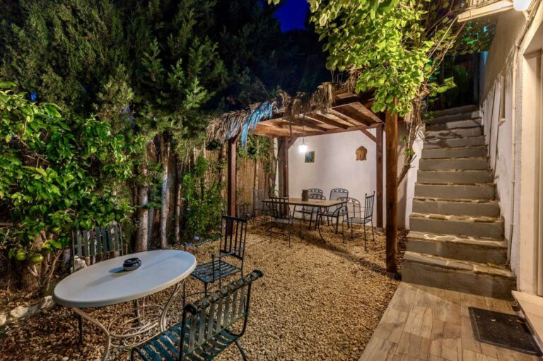 Garden seating area at a Benissa sea view villa with outdoor table, pergola, steps and Mediterranean planting