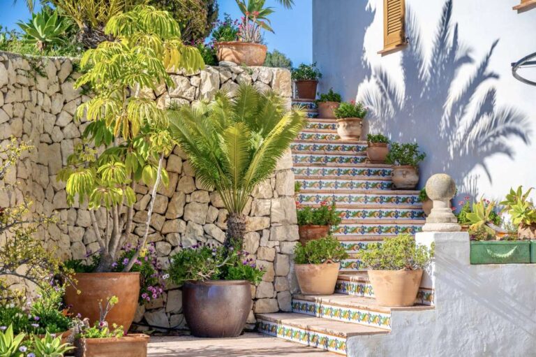 Garden steps at a traditional Spanish finca near Moraira with tiled risers, stone walls, potted plants and Mediterranean planting