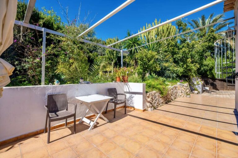 Garden terrace at a Mediterranean villa in Benissa Costa near Cala Baladrar with outdoor seating, tiled terrace and mature greenery