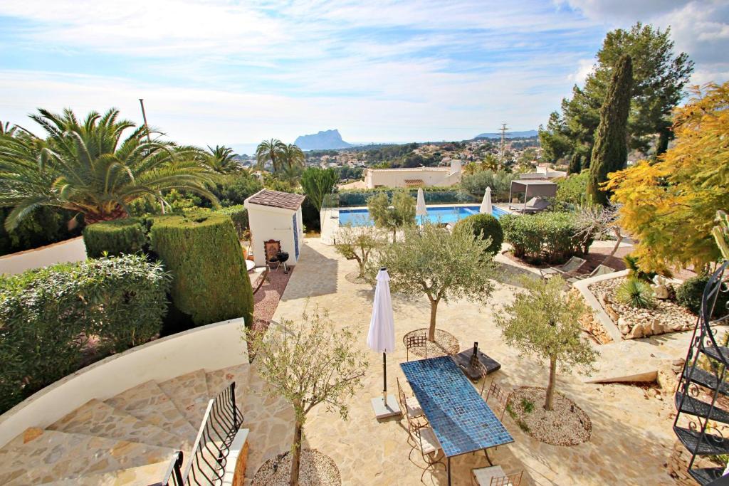 Garden terrace with pool and views towards the Peñón de Ifach at Moraira villa