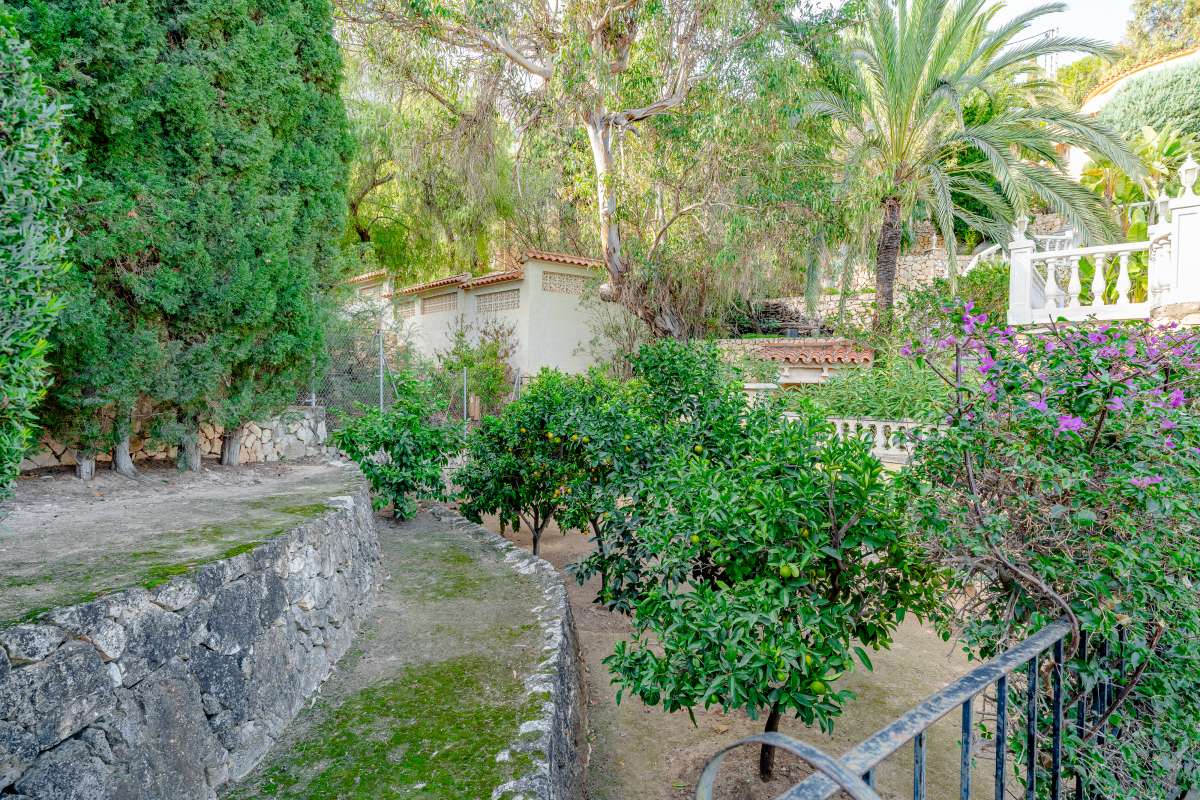 Garden view with Mediterranean planting and stone retaining wall at a villa in Maryvilla, Calpe.