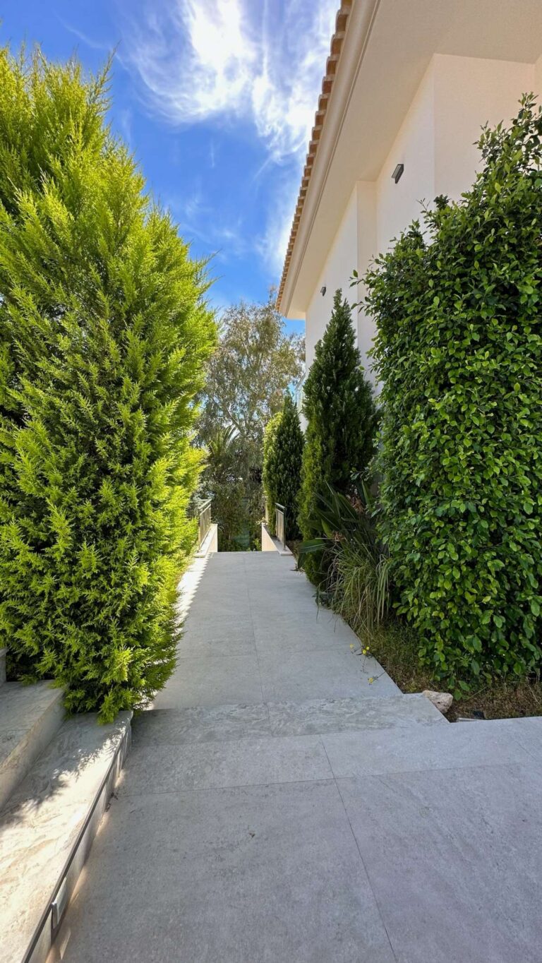 Garden walkway at a modern luxury villa in La Calalga, Calpe with tall hedges, side access and landscaped Mediterranean planting