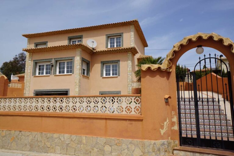 Gated entrance and exterior view of a Mediterranean villa near La Calalga Beach in Calpe.