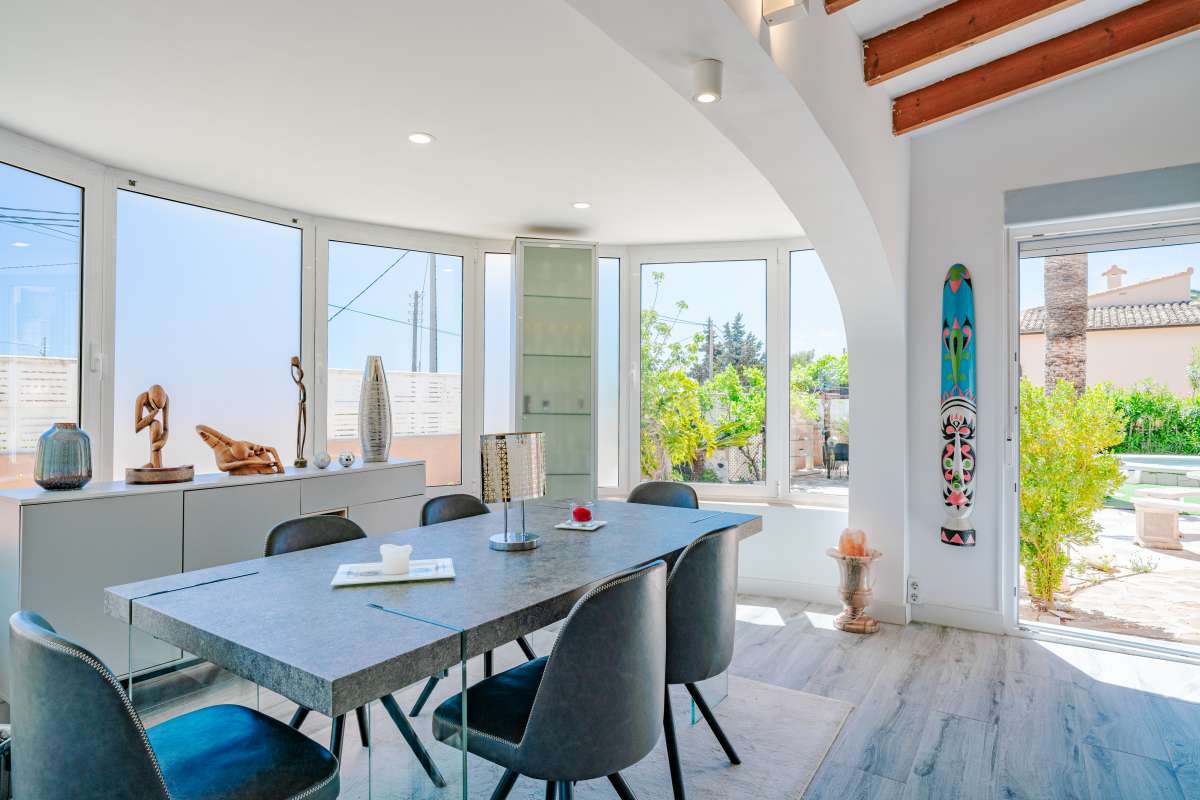 Glazed terrace with dining area and garden access inside a renovated Mediterranean villa in La Cometa, Calpe.
