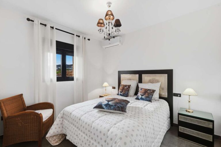 Guest bedroom inside a premium coastal villa on the Benissa Costa with double bed, white interior, window and air conditioning
