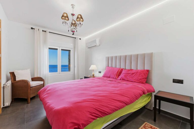 Guest bedroom inside a premium coastal villa on the Benissa Costa with sea views, bright white interior, air conditioning and pink bedding