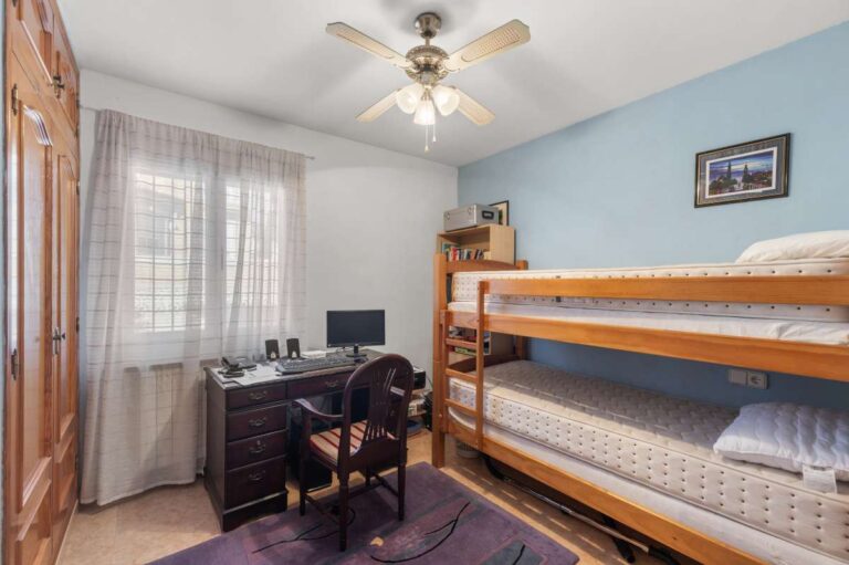Guest bedroom with bunk bed, desk and natural light inside a single-level villa in Calpe close to amenities.