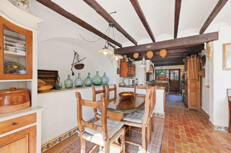 Guest house dining area inside a traditional Spanish finca near Moraira with beamed ceiling, rustic kitchen, wooden dining table and Mediterranean details