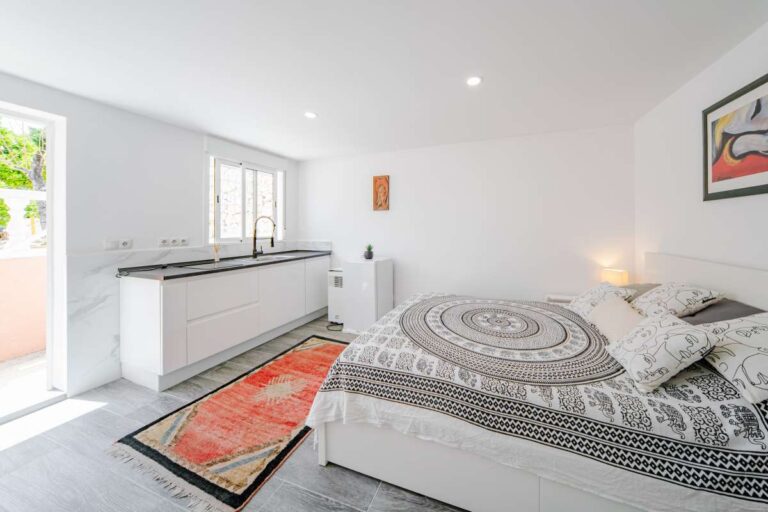 Guest suite bedroom with kitchenette and light modern interior at a renovated Mediterranean villa in La Cometa, Calpe.