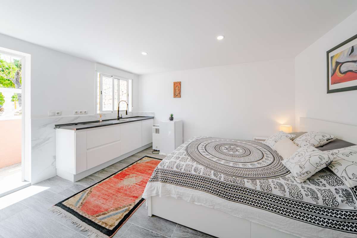 Guest suite bedroom with kitchenette and light modern interior at a renovated Mediterranean villa in La Cometa, Calpe.
