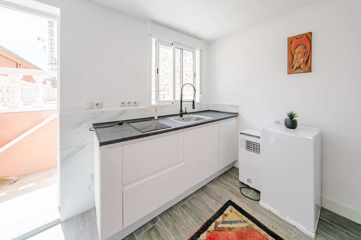 Guest suite kitchenette with sink, modern cabinets and natural light at a renovated Mediterranean villa in La Cometa, Calpe.