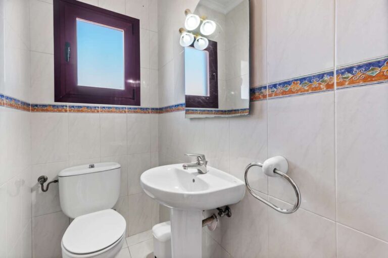 Guest toilet with sink and natural light inside a spacious villa with guest apartments in Calpe.