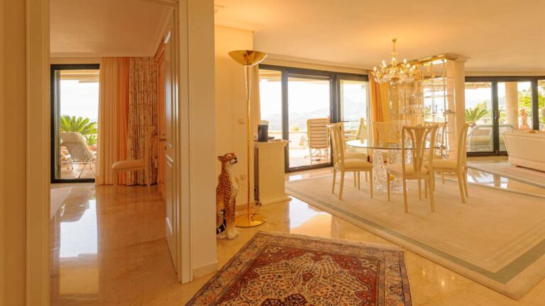 Hallway and dining area inside a luxury apartment in Sierra de Altea with marble flooring, chandelier lighting, open-plan layout and terrace access