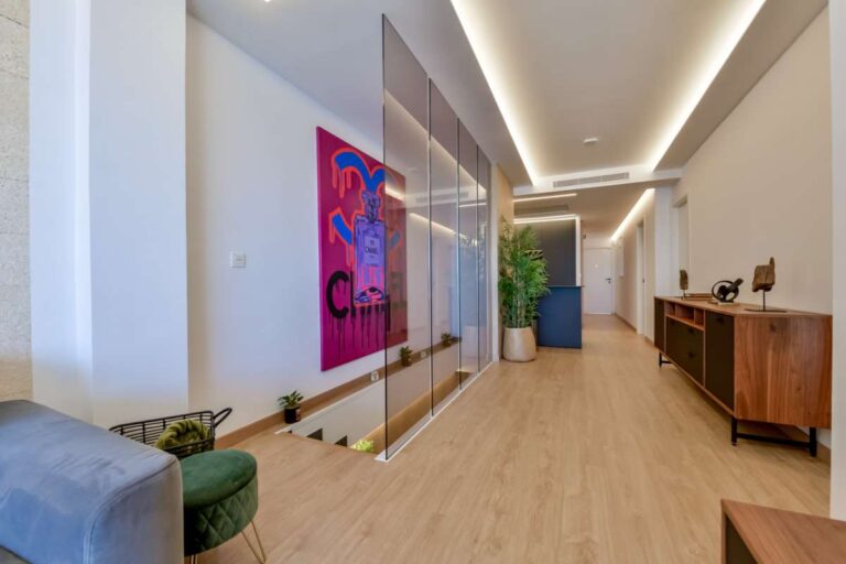 Hallway and lounge area inside a luxury frontline beach duplex in Mascarat, Altea with modern artwork, sofa seating and wood-effect flooring
