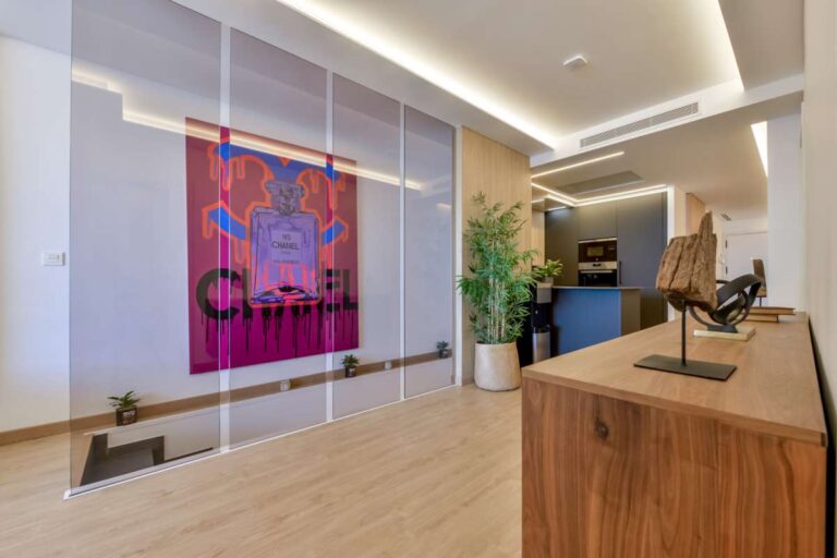 Hallway inside a luxury frontline beach duplex in Mascarat, Altea with feature artwork, console table, indoor planting and modern lighting
