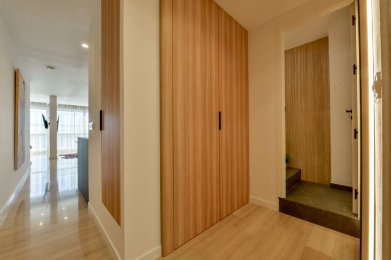 Hallway inside a luxury frontline beach duplex in Mascarat, Altea with fitted wardrobes, stair access, modern doors and wood-effect flooring