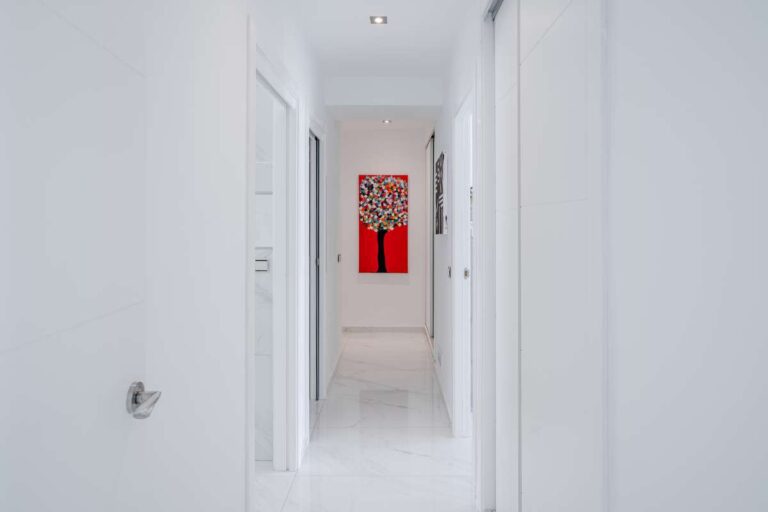 Hallway inside a renovated apartment in Arenal-Bol, Calpe with bright white walls, modern finish and access to the bedrooms