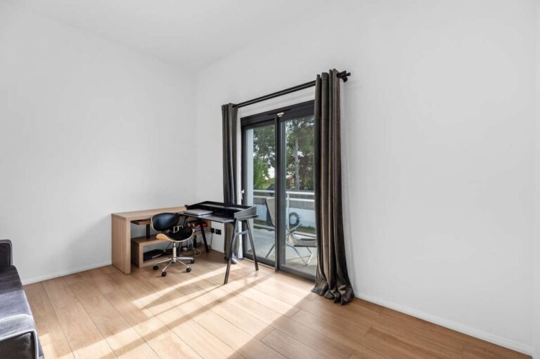 Home office inside a single-level modern villa in Santa Clara, Altea with desk area, wood flooring, large window and bright modern interior