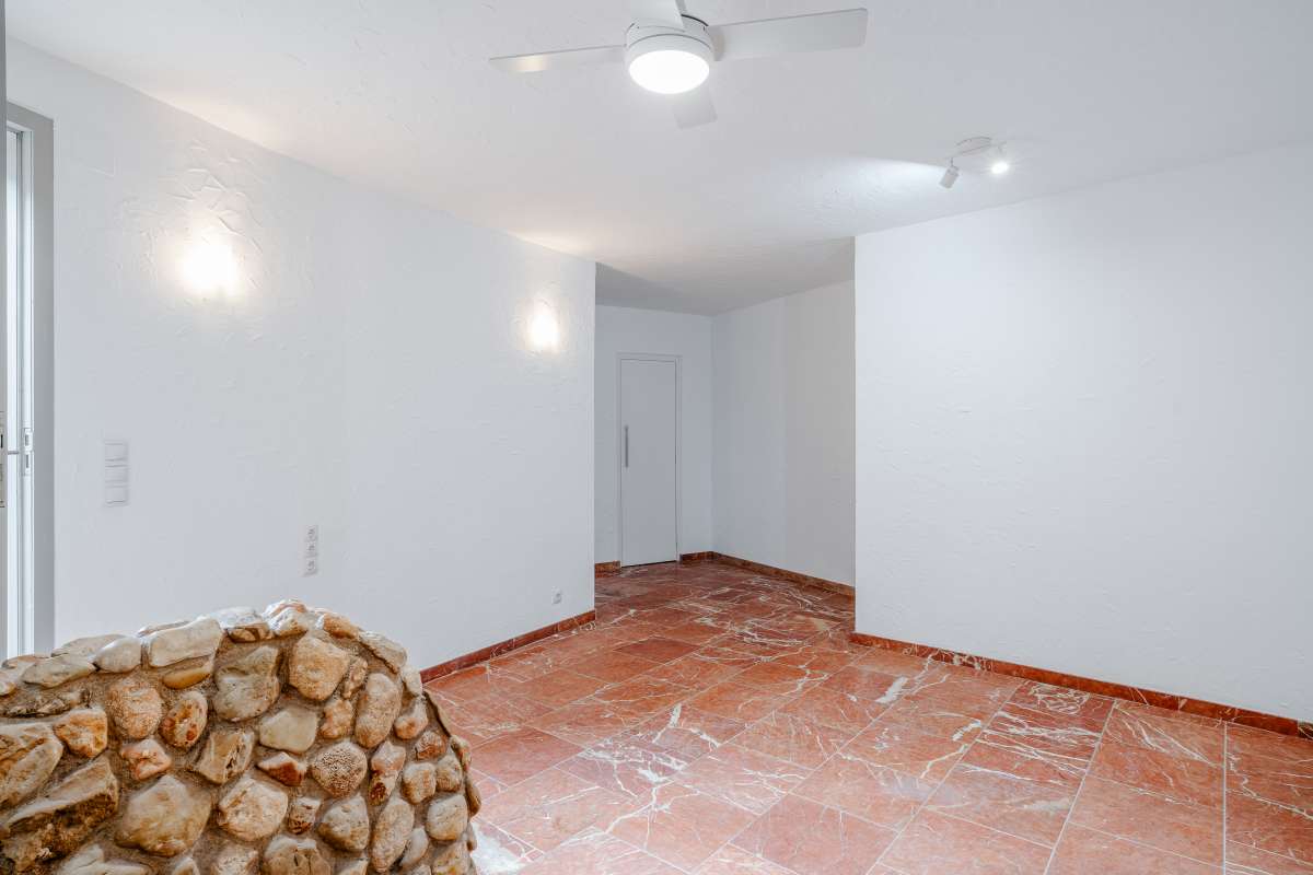 Independent apartment interior with terracotta flooring, stone feature wall and white walls at a Mediterranean villa in Maryvilla, Calpe.