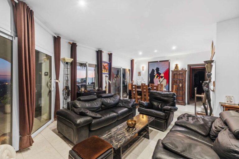 Independent living room inside a Benissa sea view villa with leather sofas, terrace access and traditional interior details