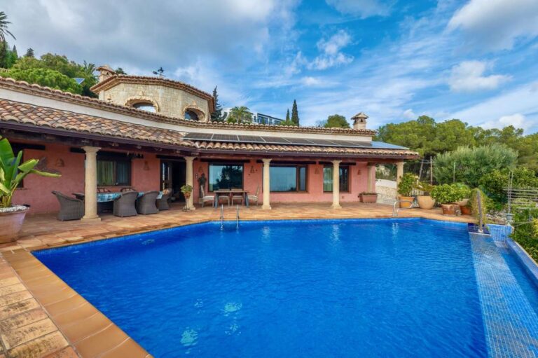 Infinity pool at a finca-style villa in Benissa Costa with covered terrace, natural stone architecture, sea views and Mediterranean garden surroundings