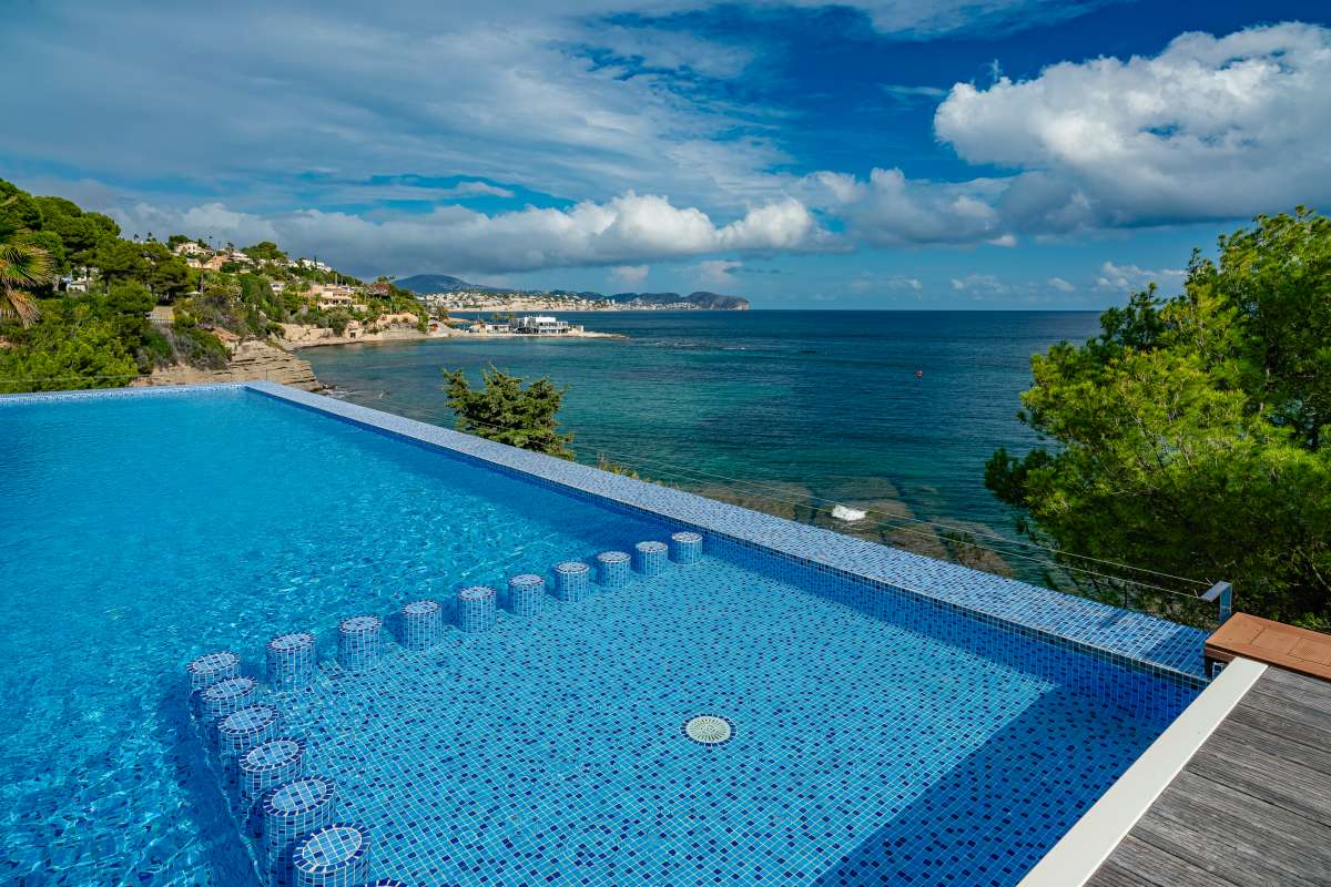 Infinity pool with bay views and Mediterranean coastline at a frontline villa in Les Bassetes.