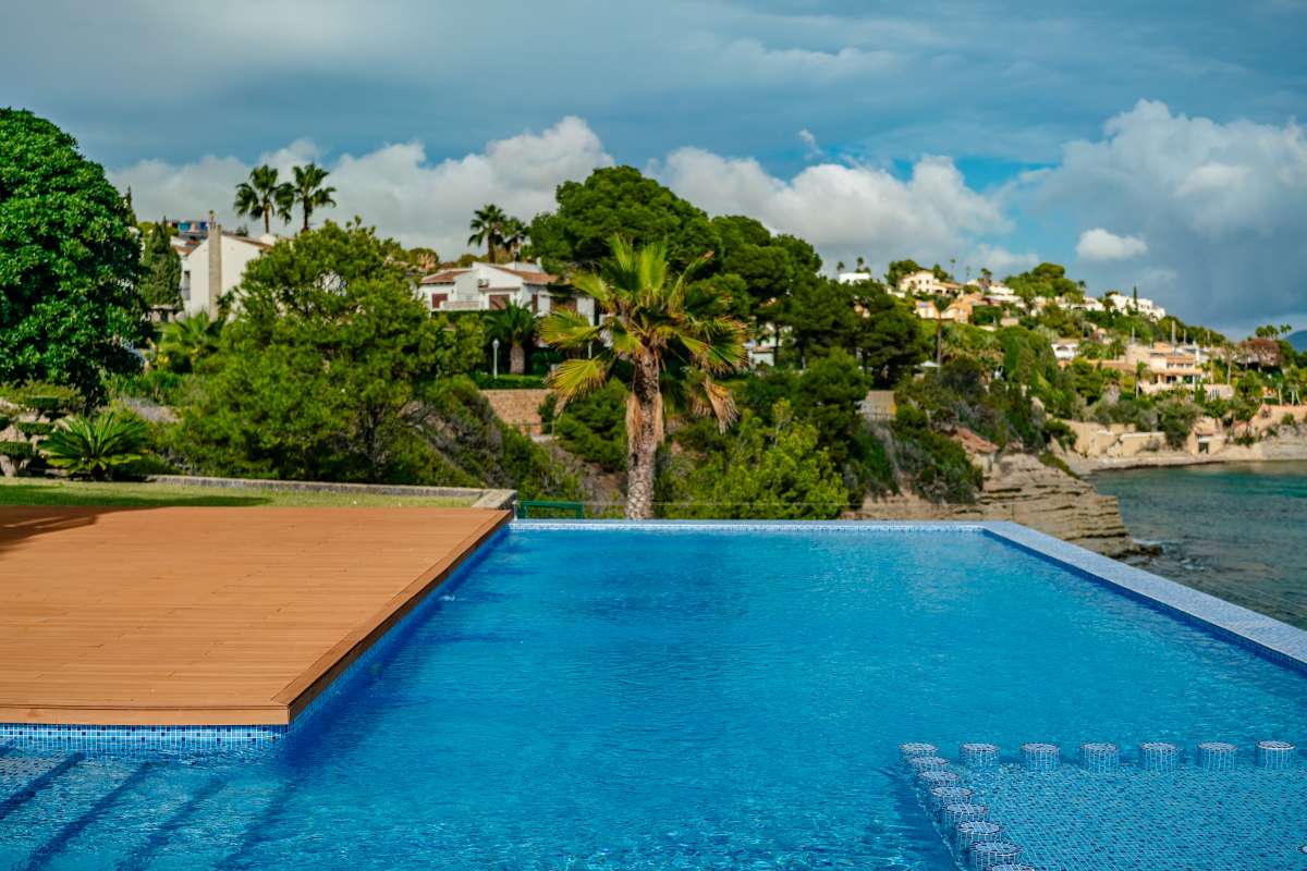 Infinity pool with sea views and coastline outlook at a frontline villa in Les Bassetes, Benissa Coast.