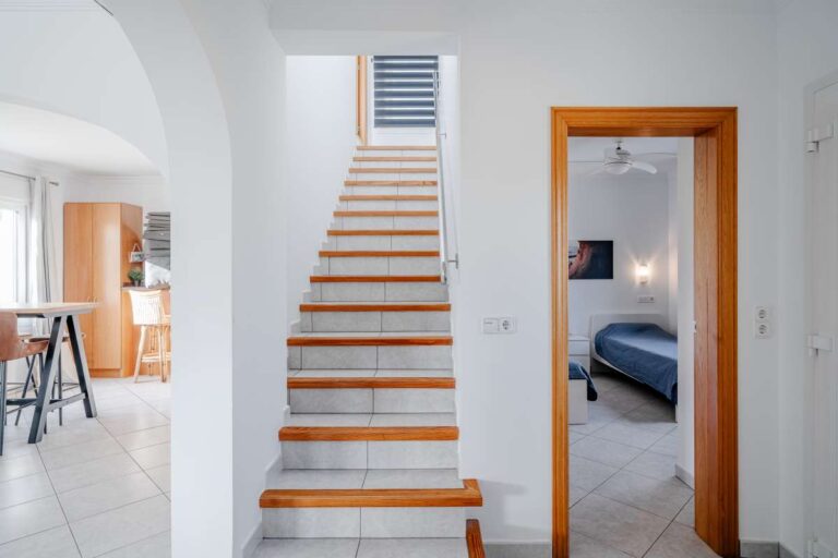 Interior hallway of a villa in Calpe with staircase, tiled flooring and access to bedroom and kitchen areas