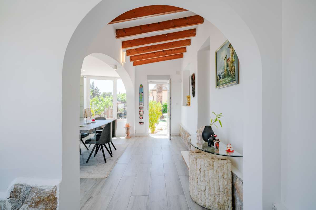 Interior hallway with arched opening and exposed ceiling beams inside a renovated Mediterranean villa in La Cometa, Calpe.