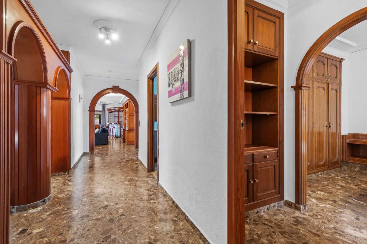 Interior hallway with arched wooden doors and tiled flooring inside a spacious villa with guest apartments in Calpe.
